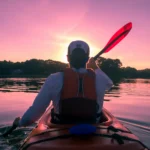 man enjoying kayaking on the evening